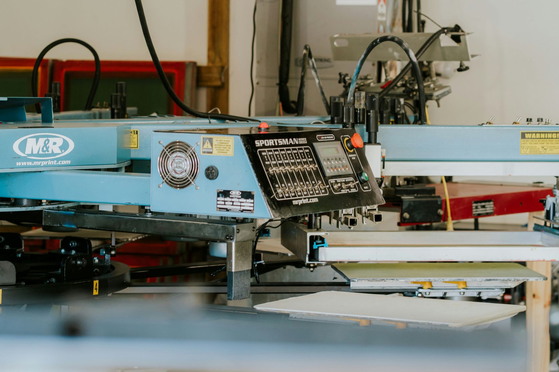 Illustration of a printing press with rollers and printed sheets